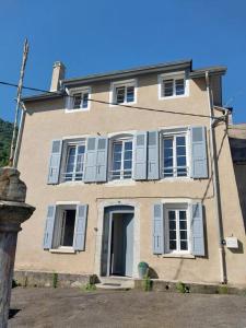 ein großes Haus mit blauen Fensterläden in der Unterkunft Maison Familiale à la Montagne in Soulom