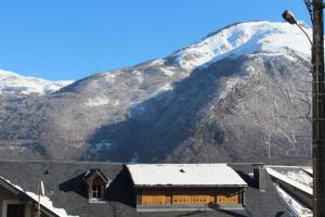ein schneebedeckter Berg vor einem Gebäude in der Unterkunft Maison Familiale à la Montagne in Soulom
