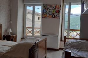 ein Schlafzimmer mit zwei Betten und einem großen Fenster in der Unterkunft Maison Familiale à la Montagne in Soulom
