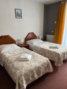 two beds in a hotel room with towels on them at Pensjonat Południe in Wieliczka