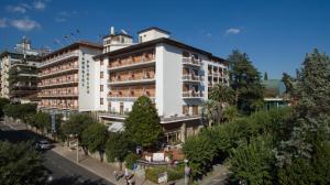 ein großes weißes Gebäude mit Bäumen davor in der Unterkunft Grand Hotel Tamerici & Principe in Montecatini Terme