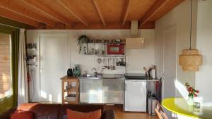a small kitchen with a stove and a refrigerator at B&B Houtstee in Veendam