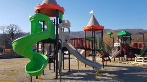 un parque infantil con un tobogán verde en Camping Paradella, en Calenzana