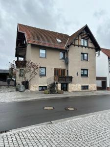 a large house on the side of a street at 2,5 Raum Ferienwohnung möbliert Dachgeschoss Niederorschel in Niederorschel