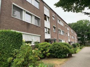 un edificio de ladrillo con arbustos delante de él en Leon’s Apartment, en Krefeld