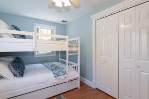 a bedroom with two bunk beds and a closet at Tranquil Home with Pool, Fireplace, and Game Room Hosts 10 in Family Friendly 4 Bedroom Home with Seasonal In Ground Pool, Ample Parking, 24 Hour Hospitality, Walk to Local Restaurants in Plymouth