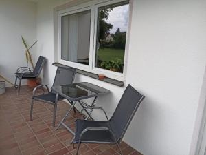 a balcony with two chairs and a table and a window at Große helle Ferienwohnung mit Balkon, ruhig gelegen mit guter Verkehrsanbindung in Bad Berneck im Fichtelgebirge