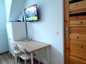 a room with a table and a tv on a wall at Sowinka in Lutowiska