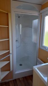 カルナックにあるMobil home sur Carnacの洗面台の隣のバスルーム(ガラス張りのシャワー付)