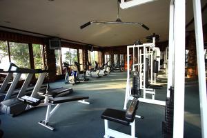 une salle de sport avec une rangée de tapis de course et de machines dans l'établissement Phu Pha Nam Resort, à Dan Sai