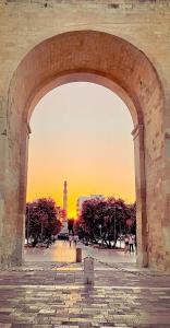 um arco de pedra com um pôr-do-sol ao fundo em Stella del Barocco em Lecce