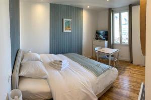 a bedroom with a large white bed and a table at Studio number 10 in Pantin