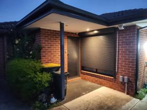 una casa de ladrillo con una ventana con persianas. en Boulder House, en Melbourne