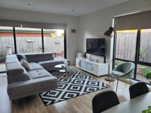 a living room with a couch and a tv at Boulder House in Melbourne