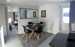 Lake view apartment, Espoo في إسبو: غرفة طعام مع طاولة سوداء وكراسي