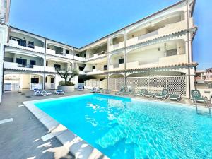 a swimming pool in front of a building at Cedro - Appartamento in residence con piscina condivisa in Orosei