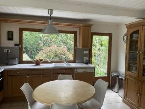 une cuisine avec une table en bois et une fenêtre dans l'établissement Maison au calme proche Paris Arena, à Issy-les-Moulineaux
