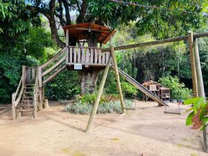 a playground with a slide in front of a tree at Ferrari Casa Nostra in Santa Teresa