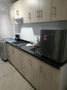 uma cozinha com um lavatório e um fogão forno superior em Apto 101 em Cúcuta