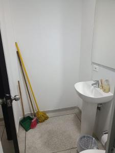 ein Badezimmer mit einem weißen Waschbecken und einem Besen in der Unterkunft Apto 101 in Cúcuta