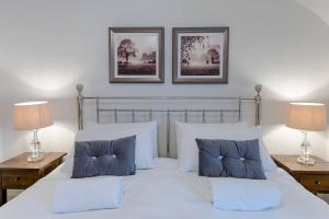 een slaapkamer met een groot wit bed met 2 lampen bij Pass the Keys Juno Apartment In the centre of historic Ludlow in Ludlow