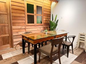 a dining room with a wooden table and chairs at Inang Street Stay - Cheng Business Park in Melaka