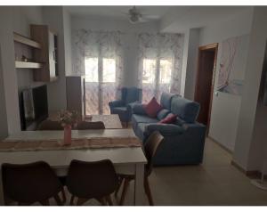 sala de estar con sofá azul y mesa en Martinete Beach Garrucha a 130m de la playa en Garrucha