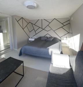 a bedroom with a bed with a geometric wall at Lake view apartment, Espoo in Espoo