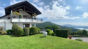 una casa en una colina con césped verde en PANORAMA - Apartment with terrace overlooking the Lake en Massino Visconti