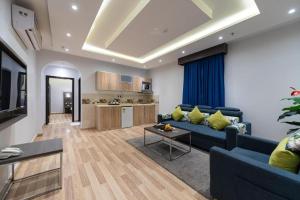 a living room with a blue couch and a kitchen at عماره هوليداي المروة- Holiday Al Marwa Building in Jeddah