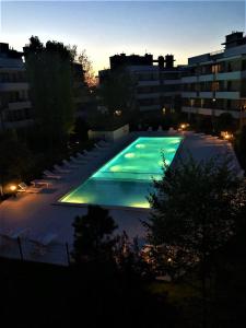 a large swimming pool in a city at night at Apartament Deluxe in Ustronie Morskie