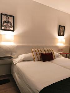 a bedroom with a bed with two pictures on the wall at Sevilla Centro Casa Del Pop in Seville