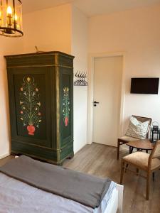 a bedroom with a green cabinet with a painting on it at Gästehaus Kleiner Wacholder in Bad Doberan