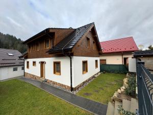 a house with a red roof and a yard at Chata pod Mníchom in Terchová