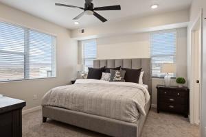 een slaapkamer met een bed en een plafondventilator bij Desert Disney condo in Atkinville