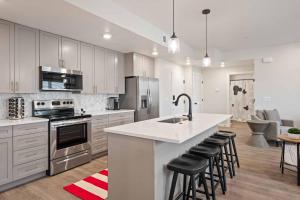 een keuken met witte kasten en een keukeneiland met barkrukken bij Desert Disney condo in Atkinville