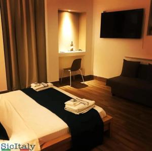 a hotel room with a bed and a chair at CBH Sicitaly group in Aci Castello +28 photos