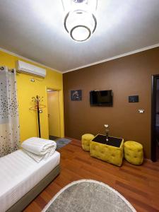 salon z kanapą i 2 żółtymi krzesłami w obiekcie Bora Hotel w Gjirokastrze