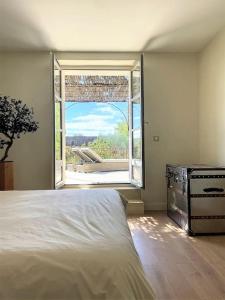 um quarto com uma cama e uma grande janela em La Casalissa em Flaux