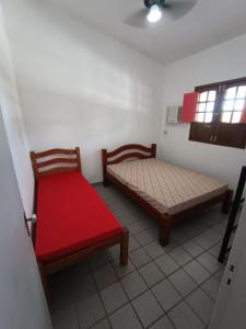a room with two beds and a red bench at Onda Colorida - Praia de Serrambi (CASA 1 - ROSA) in Porto De Galinhas