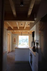 a kitchen with white cabinets and a window at chalet montagne la lupina in Les Orres