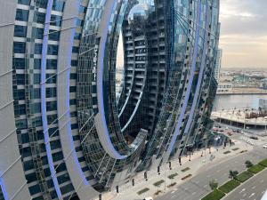 Ashri HH, Apt with Canal View في دبي: مبنى زجاجي طويل وتصميم حلزوني عليه
