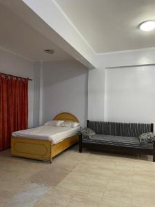 a bedroom with a bed and a bench in it at Luxorya hotel apartment in Nag` Naqsha