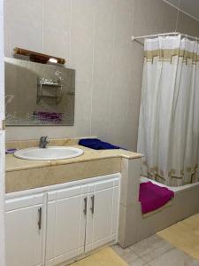a bathroom with a sink and a shower curtain at Luxorya hotel apartment in Nag` Naqsha
