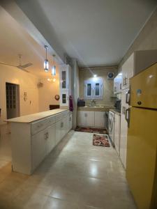 eine große Küche mit weißen Schränken und einem Waschbecken in der Unterkunft Luxorya hotel apartment in Nag` Naqsha