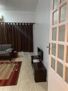 ein Wohnzimmer mit einem Sofa und einem TV in der Unterkunft Luxorya hotel apartment in Nag` Naqsha