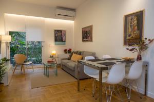 ein Wohnzimmer mit einem Tisch und einem Sofa in der Unterkunft Comfort & Elegance in Kolonaki - 2BD Apt in Athen