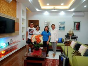 a group of people standing in a living room at PMG Islandscape Resort in Siquijor