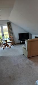 a living room with a couch and a television at Robins Nest in Ingleton 