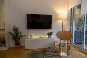 ein Wohnzimmer mit einem Stuhl und einem TV an der Wand in der Unterkunft Comfort & Elegance in Kolonaki - 2BD Apt in Athen